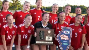 Naperville Central with girls soccer supersectional plaque