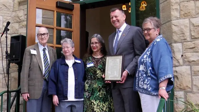 Naperville Mayor Scott Wehrli, local preservationists and members of First Congregational Church in Naperville pose for a photo with a proclamation recognizing the church as a landmark.