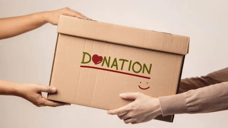 One person handing box labeled Donation to another person