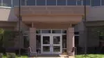 Exterior image of IPSD 204 administration building focused on the front entrance and sign