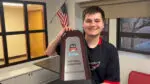 Benet academy senior holds championship trophy after winning national Esports championship for Super Smash Bros. Ultimate