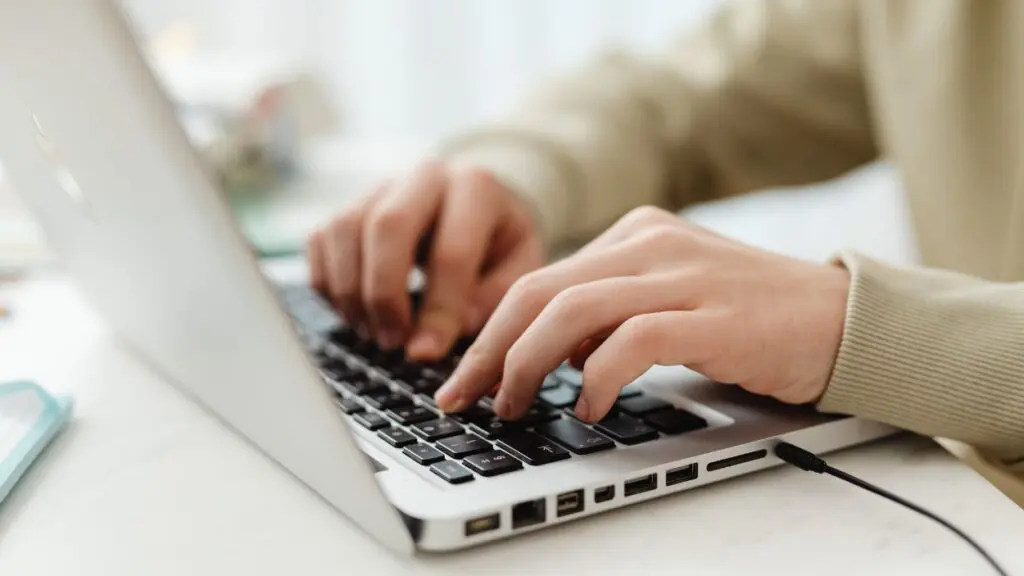 Close up of person's hands typing on computer keyboard