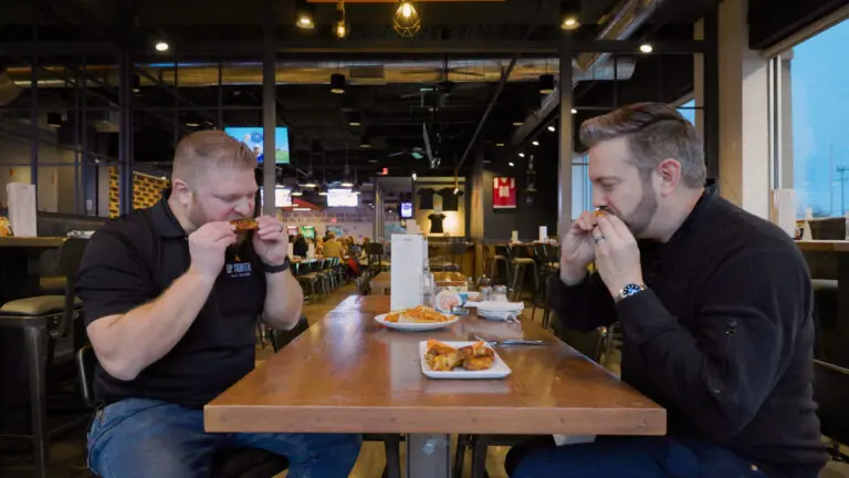 Naper Bites host Chris Grano and Dave Gavin, Up North Ale House General Manager eat wings.