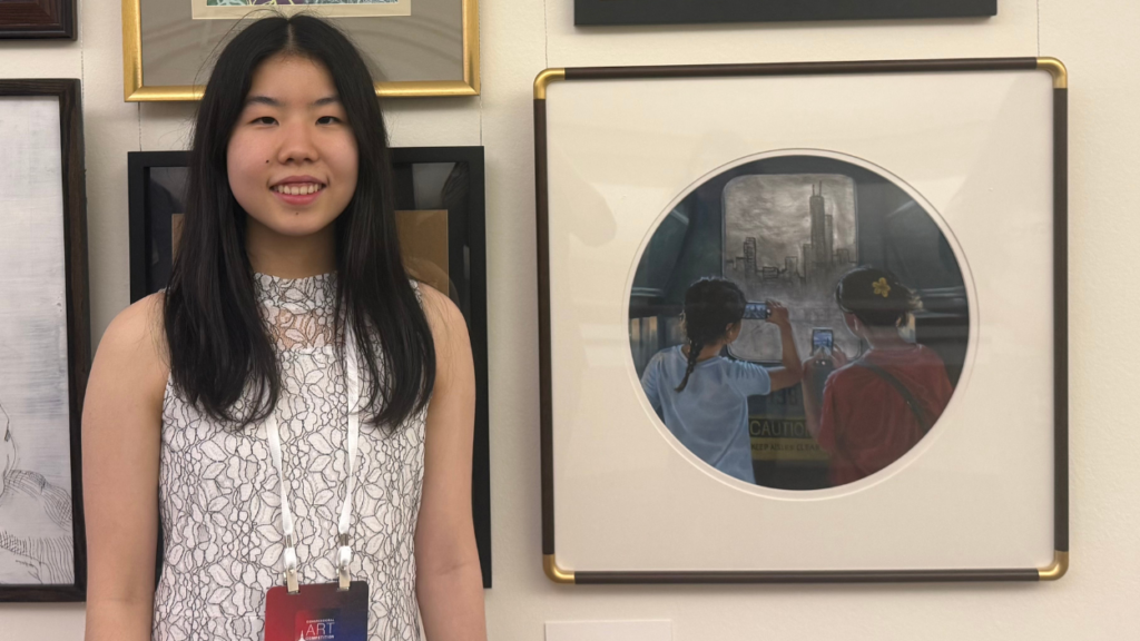 Claire Shen next to her submission "Through the Looking Glass"