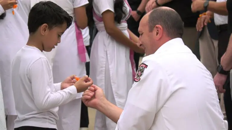HSS volunteer ties rakhi bracelet on firefighter