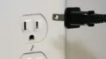 Close up of power cord by outlet