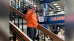 Counselor Angelo Georgacopoulos holds a mic and addresses a group of students at Naperville North High School