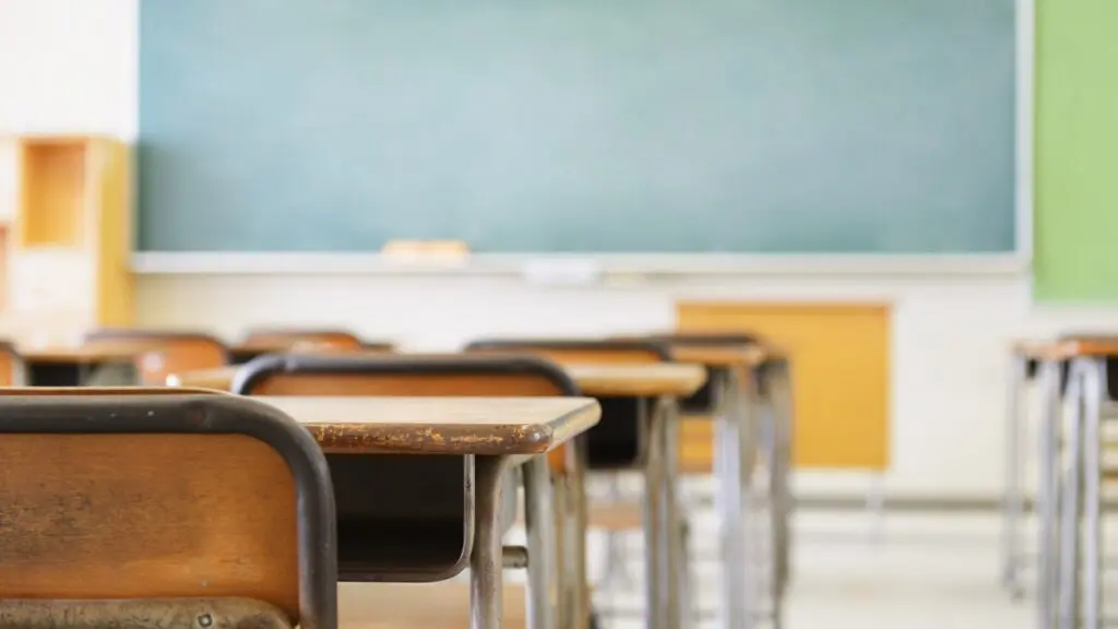 Desks in front of a whiteboard in a classroom