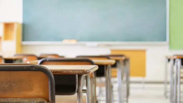 Desks in front of a whiteboard in a classroom