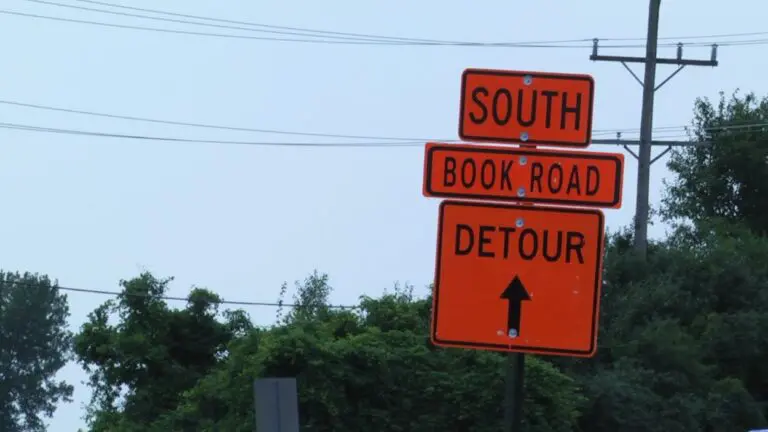 An orange detour sign points to road closures along Book Road in Naperville