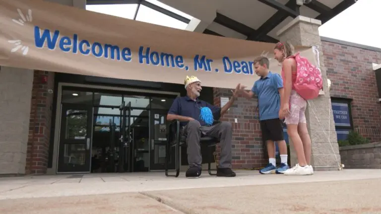 Custodian Dean Baki high-fives a student on his first day back at Scott Elementary