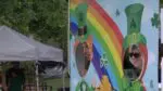 Two people pose for a photo in cut-outs of leprechauns at Naperville Irish Fest