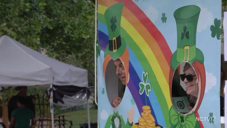 Two people pose for a photo in cut-outs of leprechauns at Naperville Irish Fest