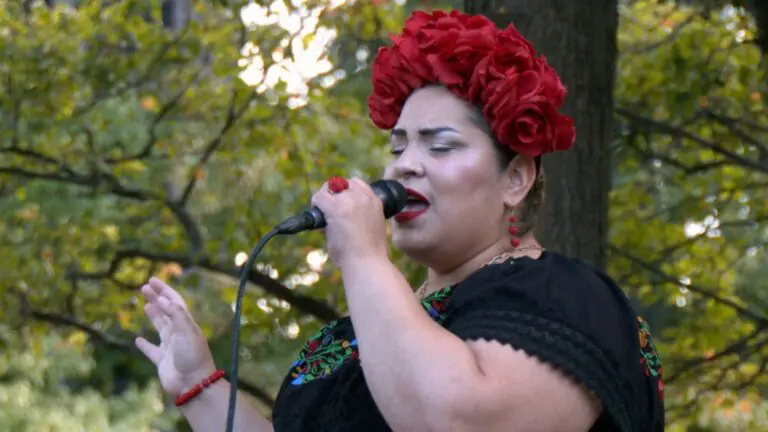 A woman sings while wearing a headband of roses at a Hispanic Heritage Month celebration