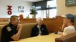 Police chief and two women sit at a table with one another
