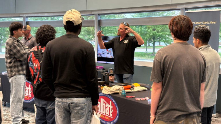 Tradesmen talks to a group of expo attendees