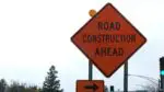 Orange road construction ahead sign