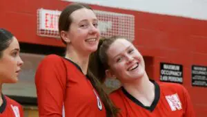 Naperville Central girls volleyball players smile before taking the court