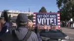 No Kings rallier holds a vote that reads "Get out and vote!"