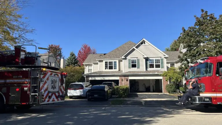 Emergency response vehicles sit outside a home after it caught fire