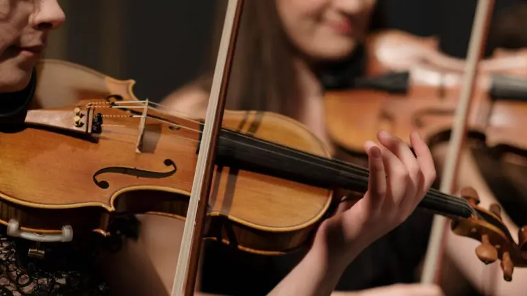 Close up of two women playing violin