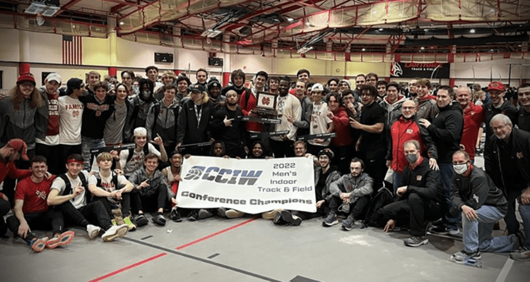 north central's men's indoor track and field team pose for a picture as a group with the CCIW championship banner