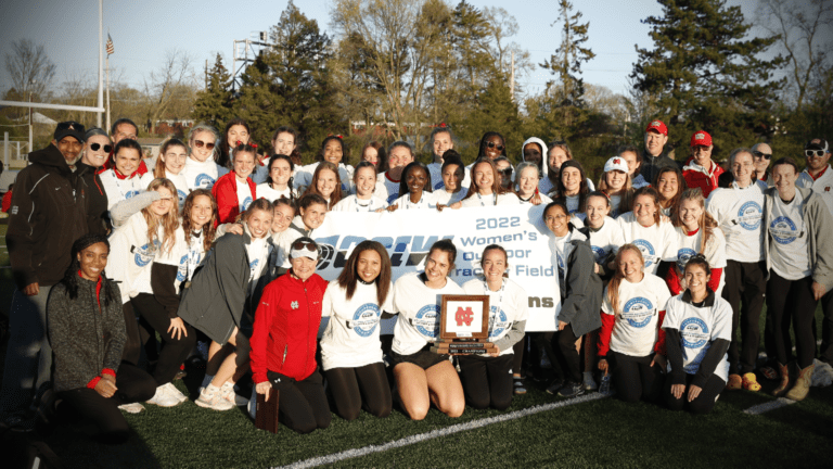 the North Central women's track and field team poses with their CCIW championship banner