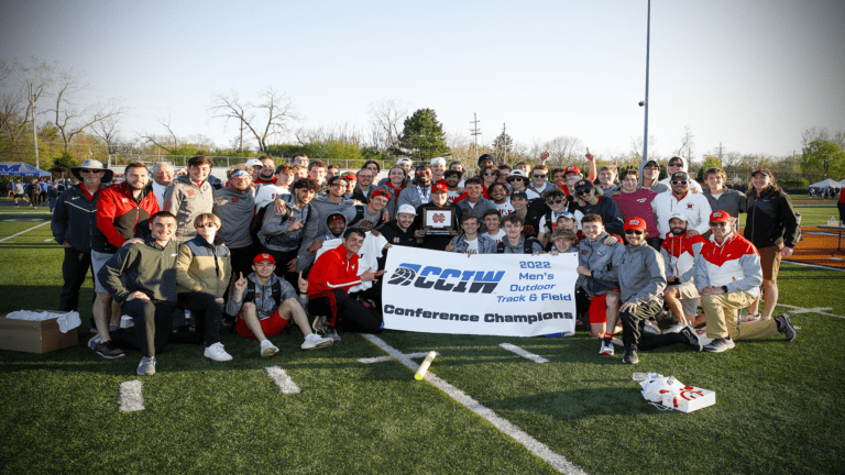 North Central men's track and field team with championship banner