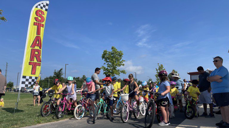 Start Flag With Kids Lined Up On Their Bikes