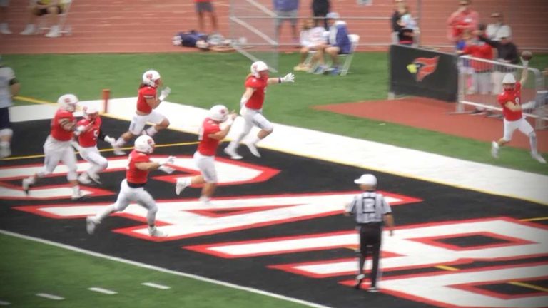 Nic Rummell and his teammates celebrate his pick-six against Elmhurst