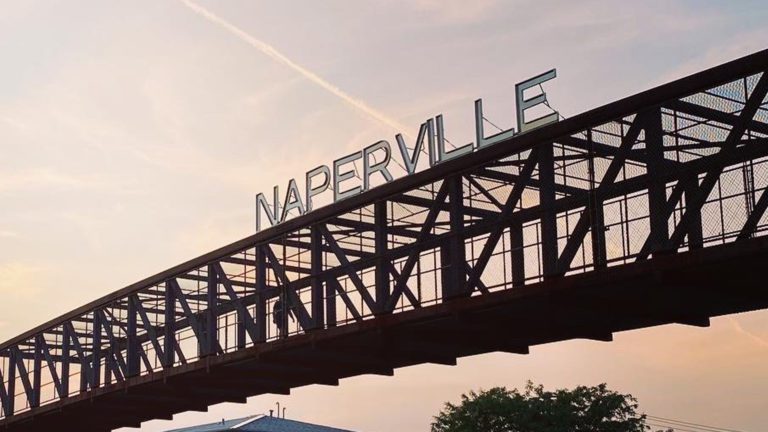 Naperville sign on pedestrian bridge over Rt.59 at sunset