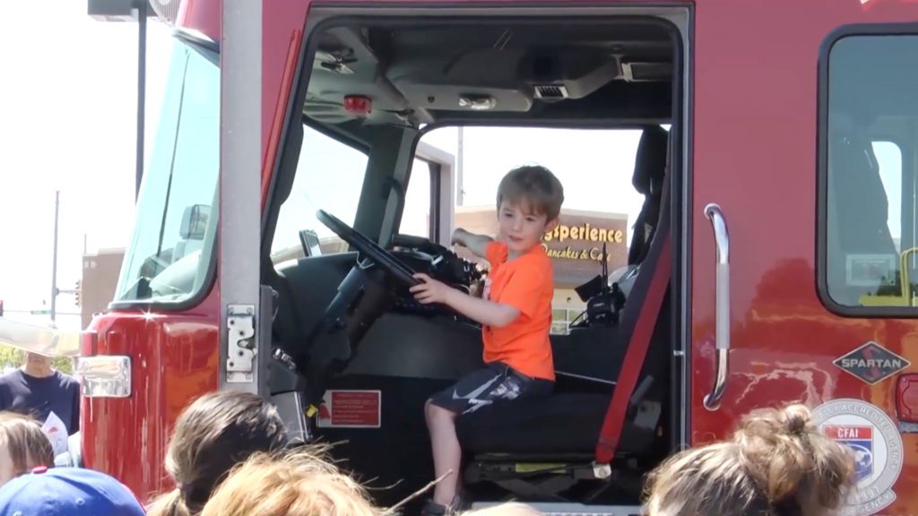 little boy sits in fire truck at wonderful wheels event