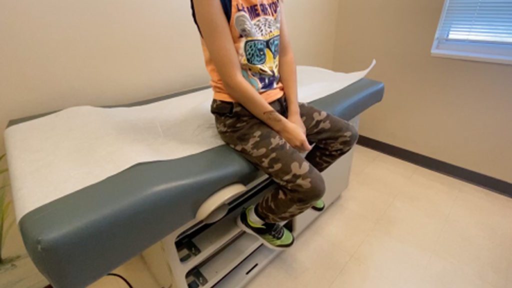 Kid Sitting On Doctors Bed