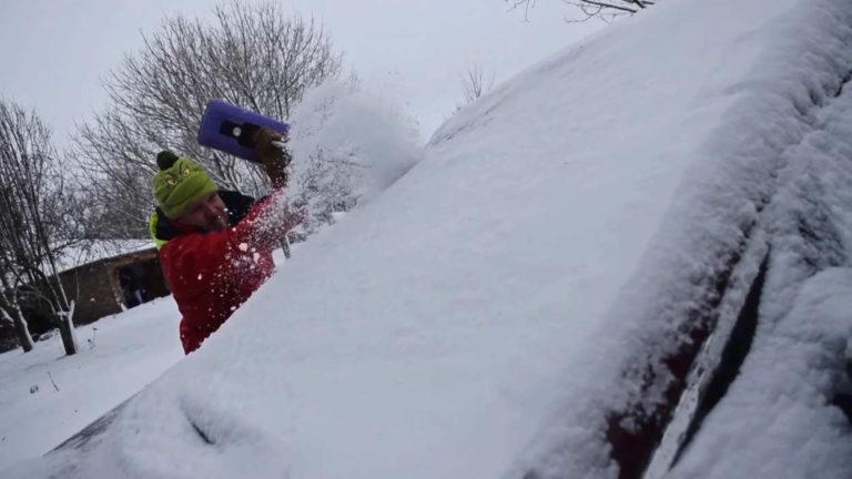 Snow removal from car, file image for winter weather advisory