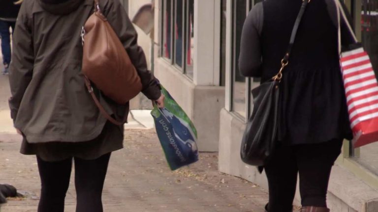 Shoppers walking on downtown Naperville sidewalk.