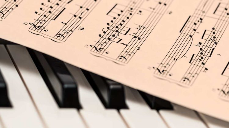 file image of sheet music sitting atop piano keys