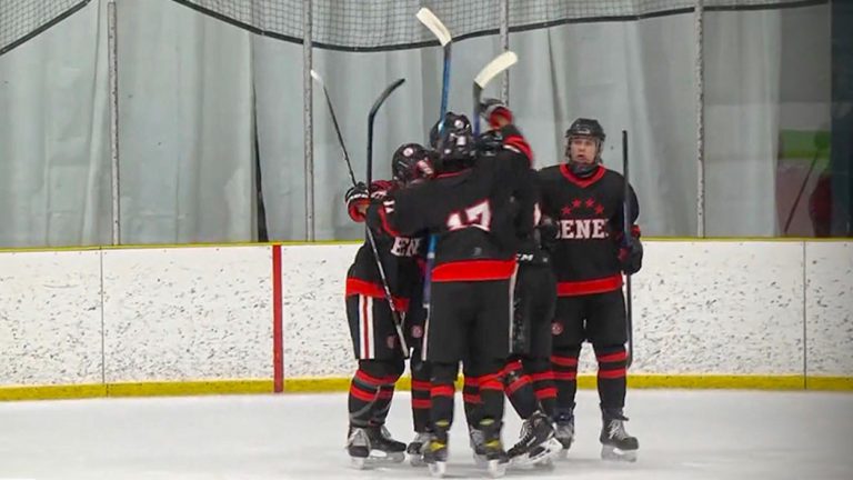 Ethan Heller hugged by his teammates
