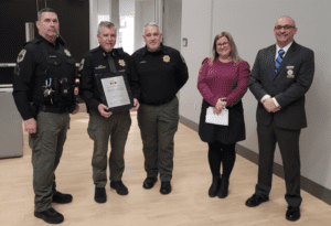 Shannon Gillette accepts an award plaque from ILEAP on behalf of the park police.