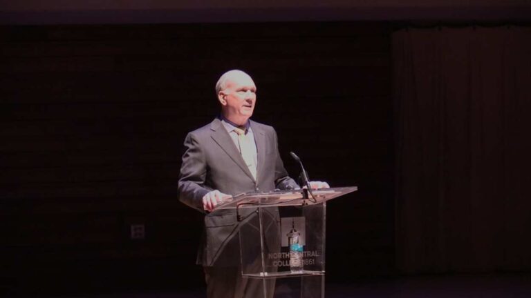 Naperville Mayor Steve Chirico standing at Wentz Concert Hall podium.