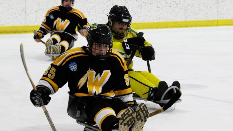 Warriors hockey player on a sled playing sled hockey