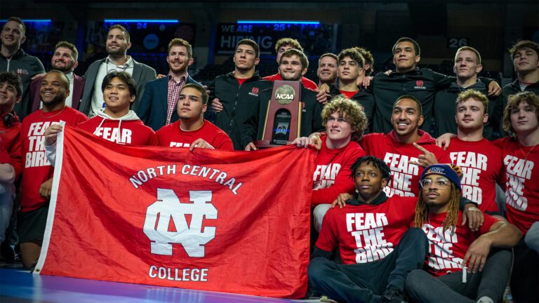 North Central men's wrestling poses with their fourth place trophy