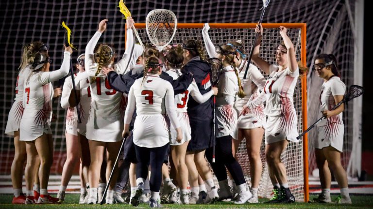 North Central Women's Lacrosse gather around the goal at the end of a game