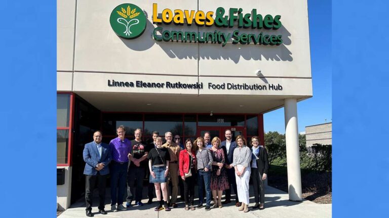 Exterior shot of newly renamed Loaves & Fishes Aurora hub, with people gathered in front