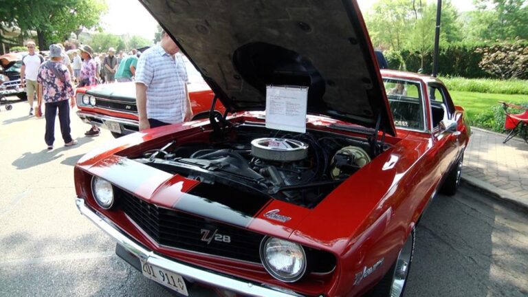Hood popped on a red car looking at the engine during Classic Car Show in Naperville