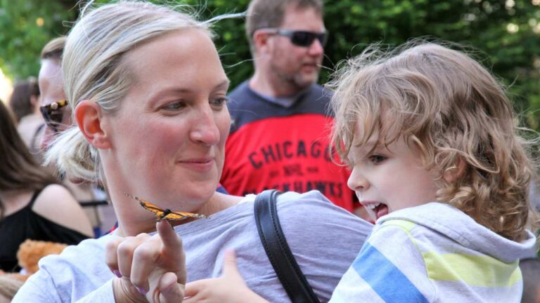 Photo of mom showing child butterfly at SHARE Wings of Hope Angel Garden event.