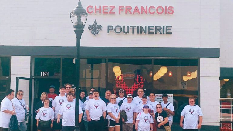 Wide shot of Chez Francois Poutinerie with staff in front