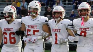 Benet Academy football captain head to the coin toss before the game against De La Salle.