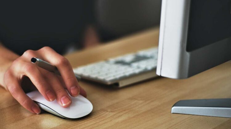 File image of hand on mouse and computer keyboard