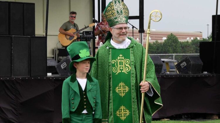 A man dressed as St. Patrick and a boy dressed as a Leprechaun.