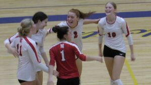 Naperville Central girls volleyball players celebrate after picking up the win against Neuqua Valley.